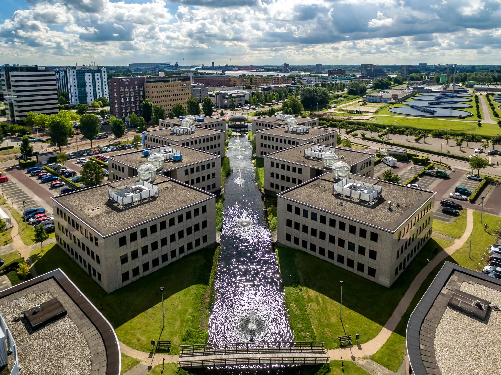 Luchtfoto van kantoorgebouwen aan de Rivium 1e Straat in Capelle aan den IJssel met een centrale waterpartij en fonteinen.